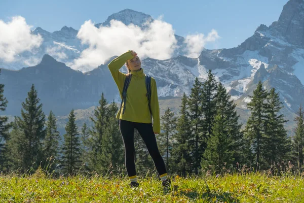 雪の山の前に立ってスイスの自然を楽しむスポーティ女性 スポーツ 自然の美しさ — ストック写真