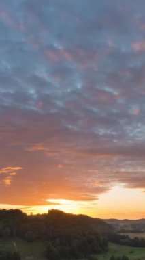 Kırsal arazinin üzerindeki dramatik günbatımı zamanı. Kırsal bölgede hareket eden pembe bulutlar.