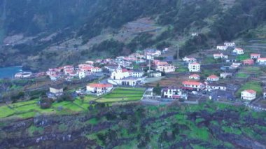 Portekiz 'deki Seixal Madeira Adaları' nın hava manzarası. Adayı kaplayan geniş bir bitki örtüsü tabakası. Dik bir okyanus kıyısındaki tatil köyü
