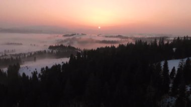 Kış sabahı bulutların üzerinde uçarak Karpat Dağları 'nda gün doğumunu..