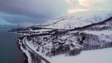 Norveç 'te kışın kışın kıyı şeridi karla kaplıydı. Kasabanın çevresi Tromso. İskandinav karından oluşan panoramik hava manzaralı dağlar, evler ve okyanus. Troms county, Fjordgard