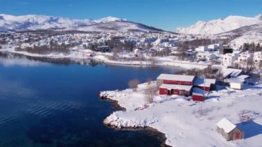Norveç 'te kışın kışın kıyı şeridi karla kaplıydı. Kasabanın çevresi Tromso. İskandinav karından oluşan panoramik hava manzaralı dağlar, evler ve okyanus. Troms county, Fjordgard