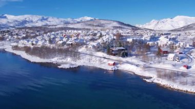 Norveç 'te kışın kışın kıyı şeridi karla kaplıydı. Kasabanın çevresi Tromso. İskandinav karından oluşan panoramik hava manzaralı dağlar, evler ve okyanus. Troms county, Fjordgard