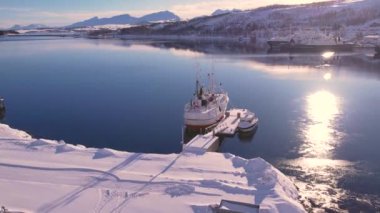 Kuzey Norveç, Tromso limanındaki balıkçı teknesinin insansız hava aracı görüntüsü. Güneşli kış günü