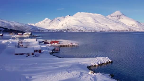 挪威沿海的渔村被雪覆盖 环城特罗姆瑟 挪威山脉 船只和海洋的全景空中景观 特罗姆斯县 Fjordgard — 图库视频影像