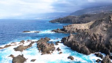 Okyanus dalgalarının hava izleme görüntüsü lav kayaları arkaplanına, Tenerife adasına, Kanarya adalarına, İspanya