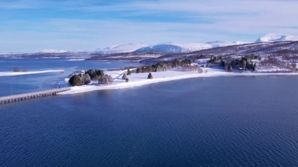 挪威海岸线上的雪盖着山脉 环城特罗姆瑟 北部积雪的全景空中景观覆盖了高山 房屋和海洋 特罗姆斯县 Fjordgard — 图库视频影像