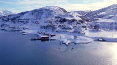Norveç 'te kışın kışın kıyı şeridi karla kaplıydı. Kasabanın çevresi Tromso. İskandinav karından oluşan panoramik hava manzaralı dağlar, evler ve okyanus. Troms county, Fjordgard