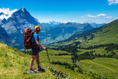 İsviçre Alplerinde yürüyüş yapan sportif bir kadın. Sağlıklı yaşam tarzı, spor, doğadaki güzellik. Grindelwald Vadisi, Swizz