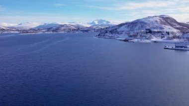 Norveç 'te kışın kışın kıyı şeridi karla kaplıydı. Kasabanın çevresi Tromso. İskandinav karından oluşan panoramik hava manzaralı dağlar, evler ve okyanus. Troms county, Fjordgard