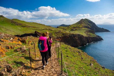 Ponta de Sao Lourenco Madeira Portekiz 'de yürüyüş yapan turistler. Yeşil arazi kayalıkları ve Atlantik Okyanusu. Gündüz, seyahat arkaplanı
