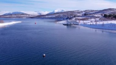 Norveç 'te kışın kışın kıyı şeridi karla kaplıydı. Kasabanın çevresi Tromso. İskandinav karından oluşan panoramik hava manzaralı dağlar, evler ve okyanus. Troms county, Fjordgard