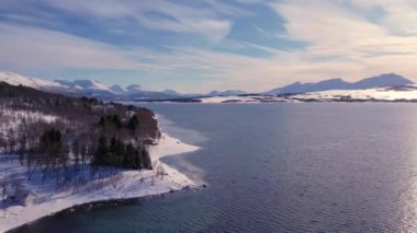 Norveç 'te kışın kışın kıyı şeridi karla kaplıydı. Kasabanın çevresi Tromso. İskandinav karından oluşan panoramik hava manzaralı dağlar, evler ve okyanus. Troms county, Fjordgard