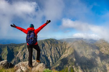 Turistler Madeira Portekiz 'de yürüyüş yolunda. Yeşil arazi kayalıkları ve Atlantik Okyanusu üzerinde. Gündüz, seyahat arkaplanı
