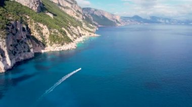 Sardegna 'nın Orosei Körfezi' ndeki Cala Goloritze 'de hava aracı görüntüsü. Sıcak turkuaz deniz, küçük plaj ve Sardunya adasında yeşil dağları olan tekneler..