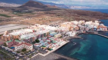 Otelleri, otelleri ve deniz plajları olan bir tatil beldesi. Hava takibi, dinlenme, güneş banyosu, bronzlaşma, tatil köylerinde seyahat. Tenerife, Kanarya Adası. Yaşam tarzı arkaplan 4K