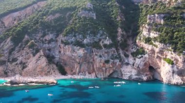 Sardegna 'nın Orosei Körfezi' ndeki Cala Baunei 'nin beyaz kumlu hava aracı görüntüsü. Sardunya adasında yeşil dağlarla çevrili ılık turkuaz deniz ve küçük plaj.