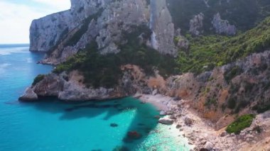 Sardegna 'nın Orosei Körfezi' ndeki Cala Goloritze 'de hava aracı görüntüsü. Sıcak turkuaz deniz, küçük plaj ve Sardunya adasında yeşil dağları olan tekneler..