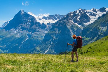 İsviçre Alplerinde yürüyüş yapan sportif bir kadın. Sağlıklı yaşam tarzı, spor, doğadaki güzellik. Grindelwald Vadisi, Swizz