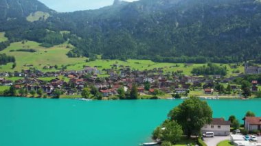 Güneşli yaz gününde İsviçre 'de Lungerersee ya da Lungerersee Gölü' nün turkuaz görüntüsü. Köy ve yeşil çayır.