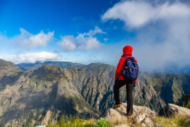 Turistler Madeira Portekiz 'de yürüyüş yolunda. Yeşil arazi kayalıkları ve Atlantik Okyanusu üzerinde. Gündüz, seyahat arkaplanı