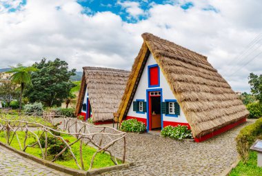 Santana köyündeki geleneksel Madeira kulübeleri ve bahçesi. Portekiz 'de güneşli bir gün, turizm beldesi
