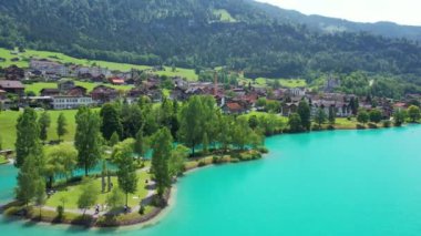 Güneşli yaz gününde İsviçre 'de Lungerersee ya da Lungerersee Gölü' nün turkuaz görüntüsü. Köy ve yeşil çayır.