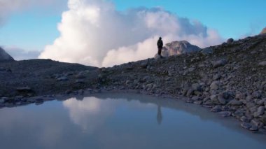 Grindelwald Vadisi 'ndeki dağların tepesinde sırt çantasıyla gezen ve güneşli günün tadını çıkaran sportif bir kadın için hava manzarası. Ekstrem spor, macera ve sağlıklı yaşam tarzı