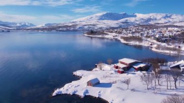 Norveç 'te kışın kışın kıyı şeridi karla kaplıydı. Kasabanın çevresi Tromso. İskandinav karından oluşan panoramik hava manzaralı dağlar, evler ve okyanus. Troms county, Fjordgard