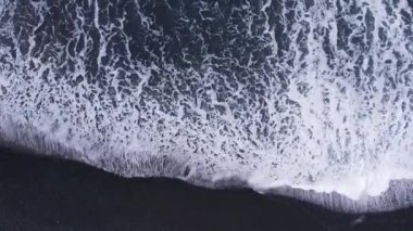 Güzel kumlu sahil manzarası. Turkuvaz deniz dalgalarıyla kıyı şeridi. Sarı kum plajı ve su yüzeyi dokusunun güzel hava aracı görüntüsü.