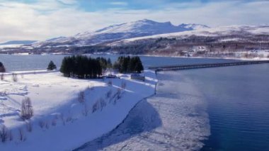 Norveç 'te kışın kışın kıyı şeridi karla kaplıydı. Kasabanın çevresi Tromso. İskandinav karından oluşan panoramik hava manzaralı dağlar, evler ve okyanus. Troms county, Fjordgard