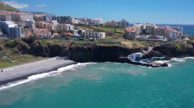 Praia Formosa sahilinin turkuaz sularının havadan görünüşü ve Funchal Madeira Adası Portekiz tepelerindeki renkli evler ve oteller