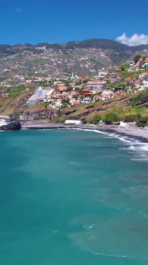 Praia Formosa sahilinin turkuaz sularının havadan görünüşü ve Funchal Madeira Adası Portekiz tepelerindeki renkli evler ve oteller