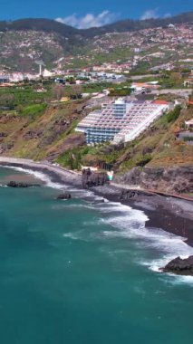 Praia Formosa sahilinin turkuaz sularının havadan görünüşü ve Funchal Madeira Adası Portekiz tepelerindeki renkli evler ve oteller