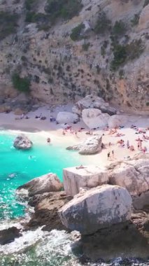 Sardegna 'nın Orosei Körfezi' ndeki Cala Baunei 'nin beyaz kumlu hava aracı görüntüsü. Sardunya adasında yeşil dağlarla çevrili ılık turkuaz deniz ve küçük plaj.