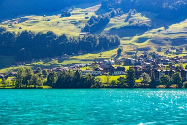 Geleneksel evleri olan İsviçre köyü Lungern, güzel zümrüt yeşili Lungerersee Gölü boyunca eski kilise Alter Kirchturm, Obwalden İsviçre kantonu.