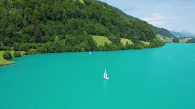 Güneşli yaz gününde İsviçre 'de Lungerersee ya da Lungerersee Gölü' nün turkuaz görüntüsü. Köy ve yeşil çayır.
