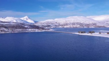 Norveç 'te kışın kışın kıyı şeridi karla kaplıydı. Kasabanın çevresi Tromso. İskandinav karından oluşan panoramik hava manzaralı dağlar, evler ve okyanus. Troms county, Fjordgard