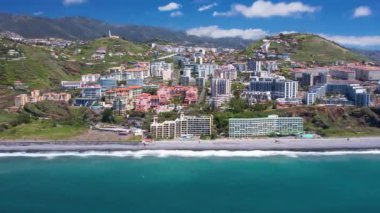 Praia Formosa sahilinin turkuaz sularının havadan görünüşü ve Funchal Madeira Adası Portekiz tepelerindeki renkli evler ve oteller