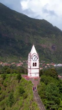 Tarihsel saat kulesi Capelinha de Nossa Senyora de Fatima yemyeşil teras manzarası ve mavi okyanus Madeira adası Portekiz ile çevrili.