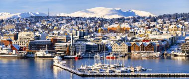 Tromso limanı evlerle, fiyortlarla, yolcu gemileriyle ve şehir merkeziyle güneşli kış günlerinde Norveç 'e seyahat