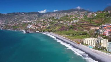 Praia Formosa sahilinin turkuaz sularının havadan görünüşü ve Funchal Madeira Adası Portekiz tepelerindeki renkli evler ve oteller