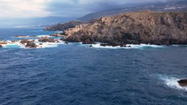 Okyanus dalgalarının hava izleme görüntüsü lav kayaları arkaplanına, Tenerife adasına, Kanarya adalarına, İspanya