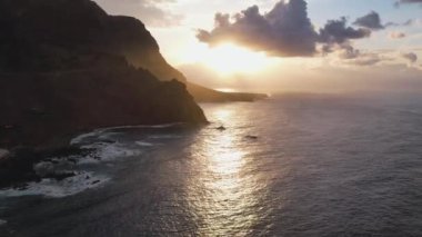 Okyanus ve Tenerife Kanarya Adası 'nın volkanik kayalıkları üzerinde gün batımı ışığı