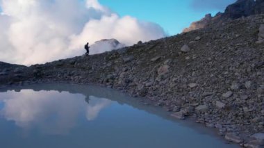 Grindelwald Vadisi 'ndeki dağların tepesinde sırt çantasıyla gezen ve güneşli günün tadını çıkaran sportif bir kadın için hava manzarası. Ekstrem spor, macera ve sağlıklı yaşam tarzı.