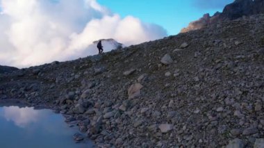 Grindelwald Vadisi 'ndeki dağların tepesinde sırt çantasıyla gezen ve güneşli günün tadını çıkaran sportif bir kadın için hava manzarası. Ekstrem spor, macera ve sağlıklı yaşam tarzı.