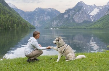 Genç kadın ve güzel Alman çoban karıştırmak köpek köpek yavrusu birlikte oturan açık bir duraklama sırasında uzun bir yürüyüş yapma