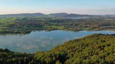 Gün batımı dağların üzerinde uçuyor ve Weissensee Gölü, Almanya. Vahşi doğa ve çam ormanı. Doğal rezerv