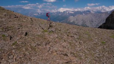 Sırt çantalı, yüksek bir dağ geçidi boyunca yürüyüş yapan sportif bayana hava manzarası. Grindelwald Vadisi İsviçre Alpleri güneşli günün tadını çıkarıyor.