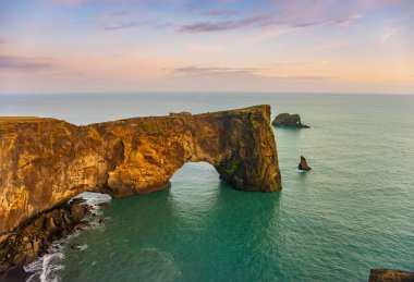 Denizde doğal lav kemeri. Cape Dyrholaey, İzlanda kıyısı. Popüler turist eğlencesi. Güzellik dünyası.